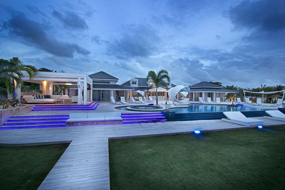 A large white house with a swimming pool in front of it