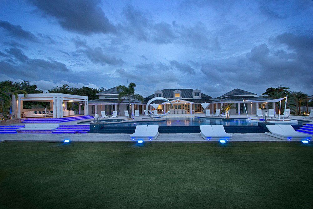 A large house with a swimming pool in front of it.