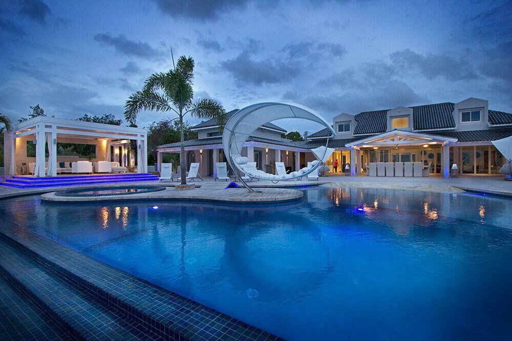 There is a large swimming pool in the middle of a large house.