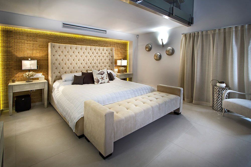 A bedroom with a king size bed and a bench.