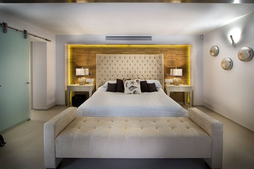 A bedroom with a king size bed and a bench.