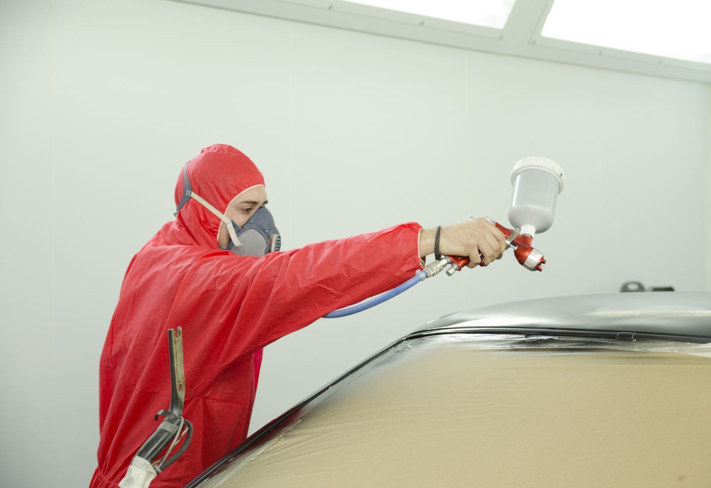 Dent removal specialist spraying new paint in Wailuku, HI