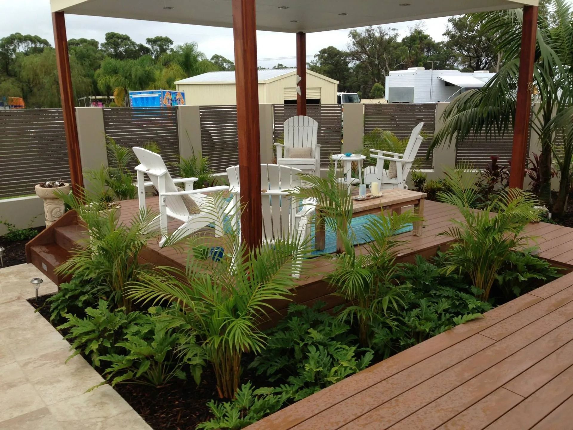 Outdoor Patio With White Chairs Under a Pergola — Divine Landscape Creations in Gosford, NSW