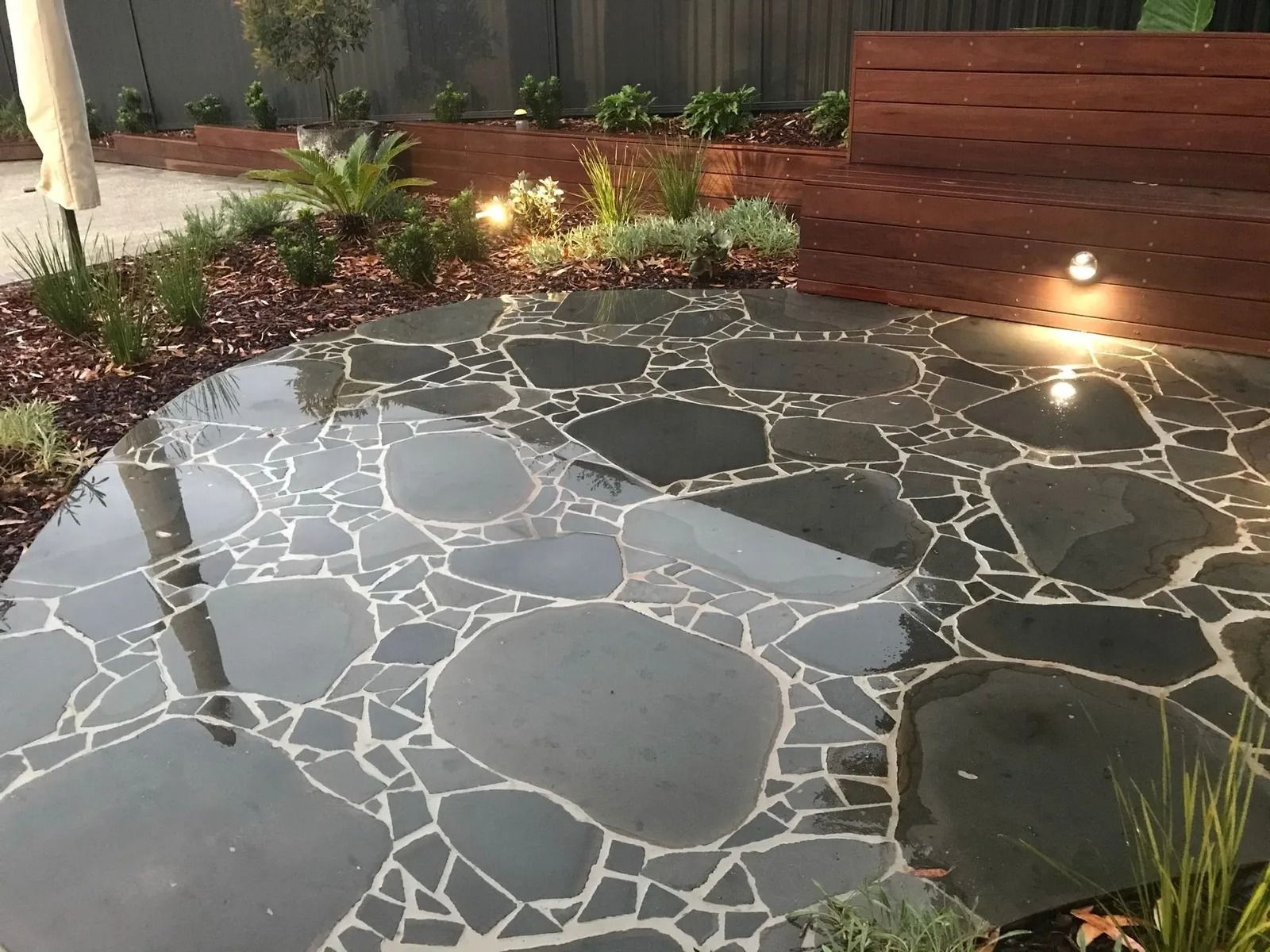 Dark Stone Patio With Irregular-shaped Tiles — Divine Landscape Creations in Berkeley Vale, NSW