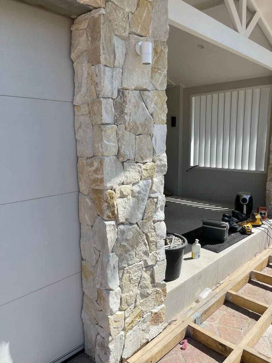 Stone-clad Pillar Next to a White Garage Door — Divine Landscape Creations in Berkeley Vale, NSW