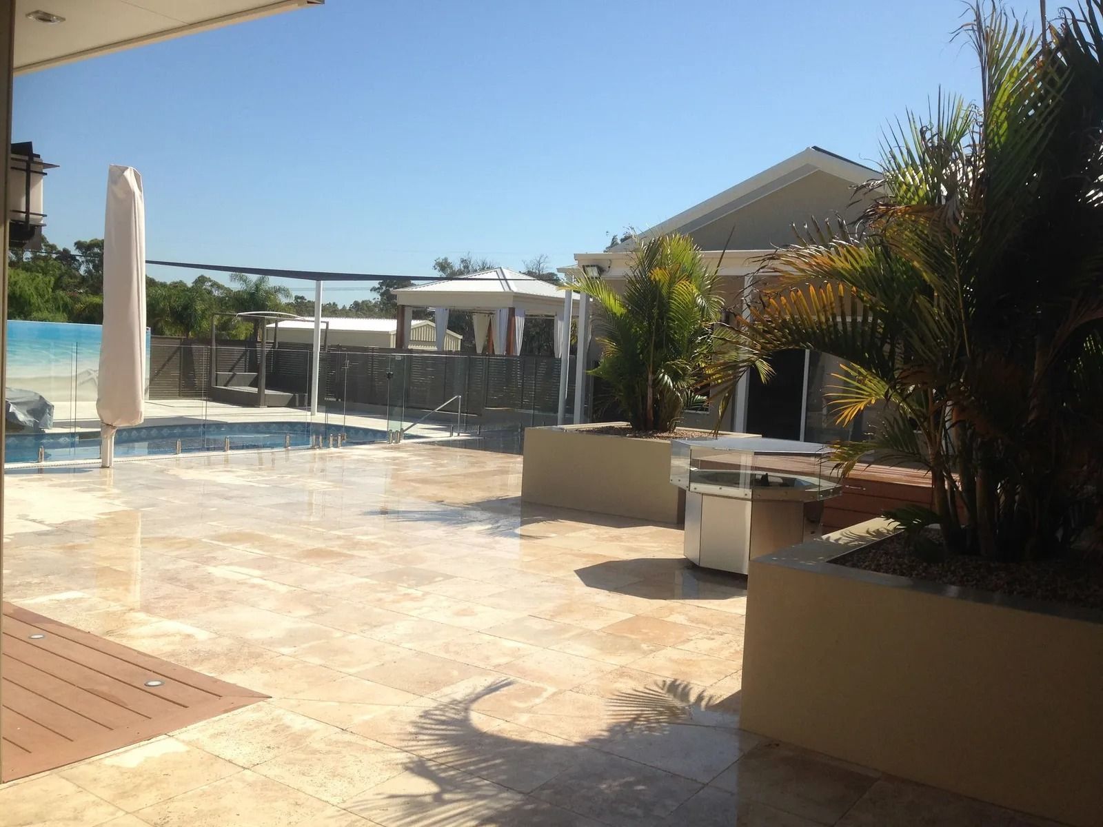 Patio With Pool, Trees, and Buildings Under a Bright, Sunny Sky — Divine Landscape Creations in Berkeley Vale, NSW
