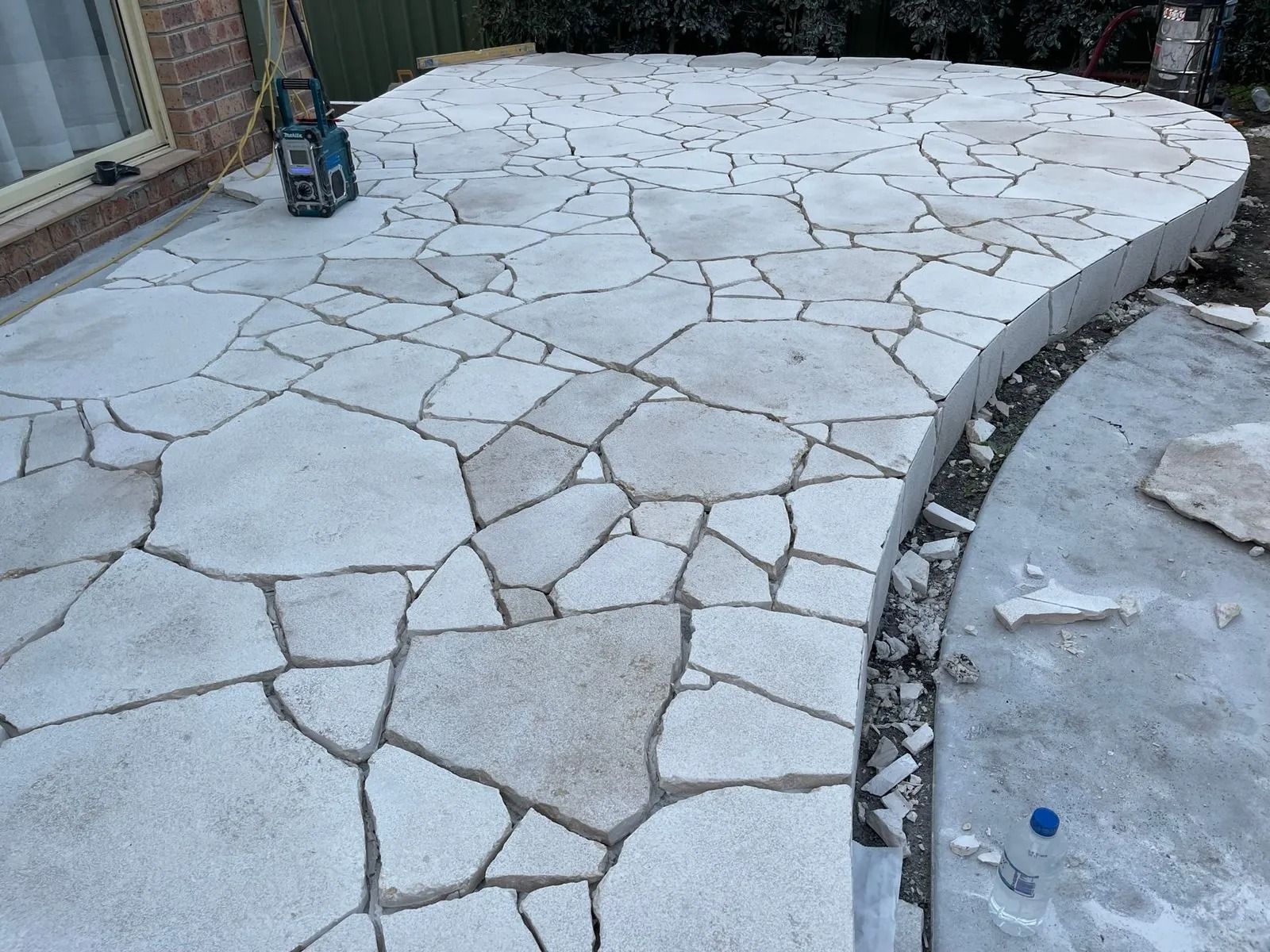 Stone Patio With Irregular-shaped Tiles — Divine Landscape Creations in Berkeley Vale, NSW