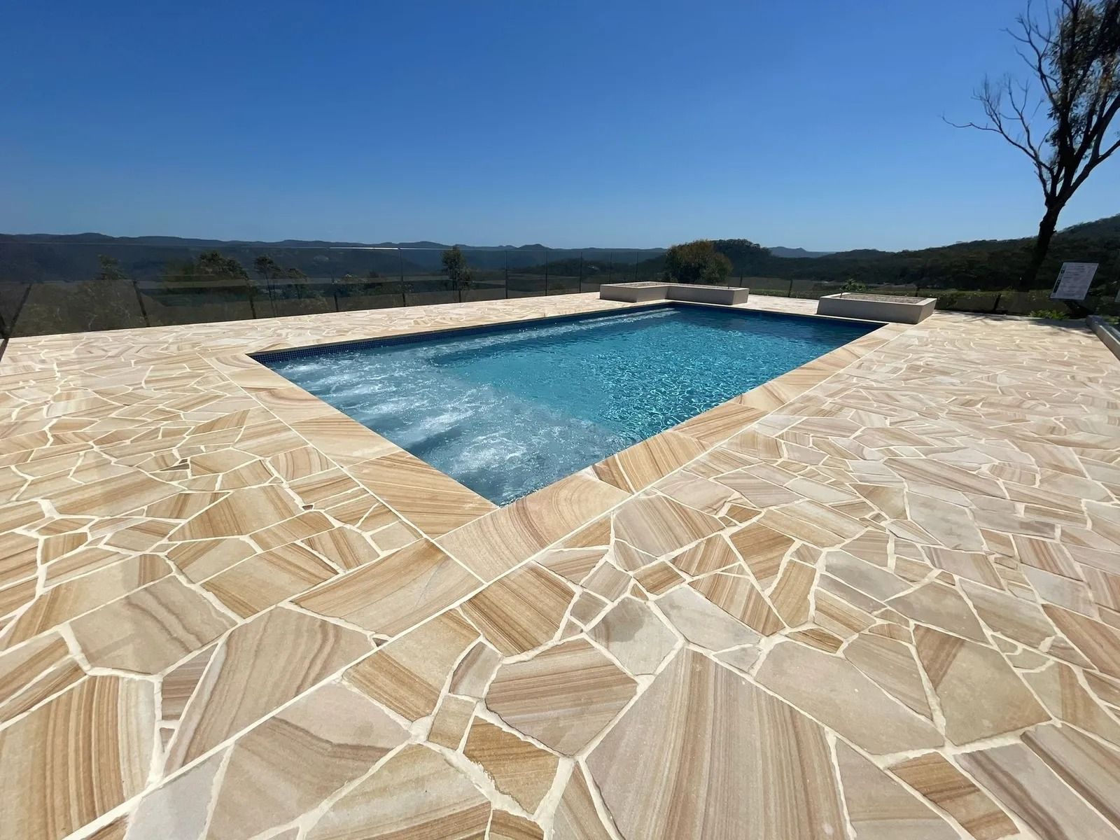 a Rectangular Swimming Pool With Tan Flagstone Patio — Divine Landscape Creations in Berkeley Vale, NSW