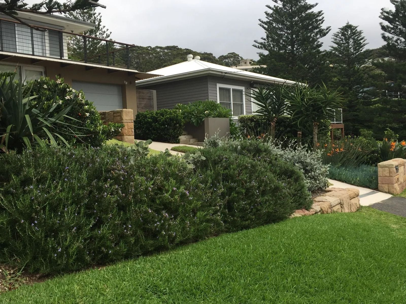 Small Gray Building With White Roof and Lush Greenery — Divine Landscape Creations in Berkeley Vale, NSW