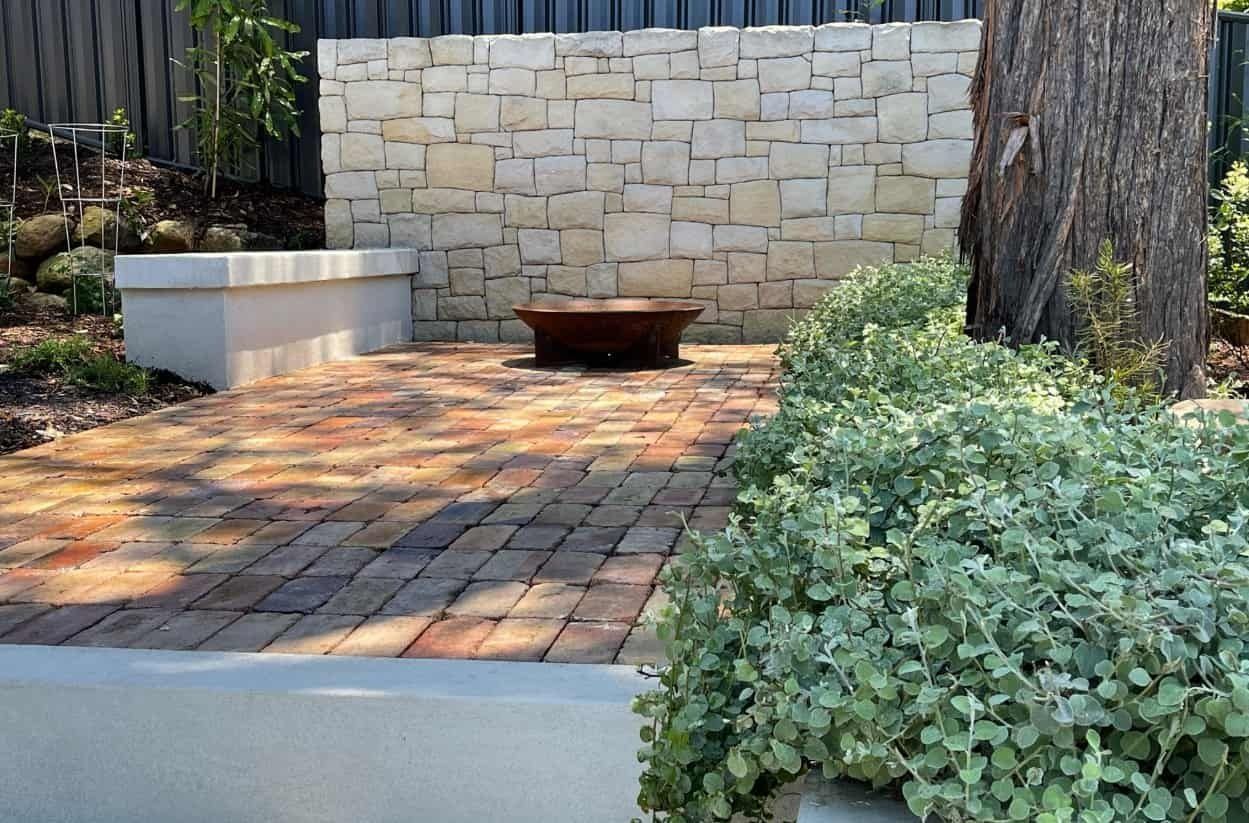 A Brick Patio With a Low Wall — Divine Landscape Creations in Berkeley Vale, NSW