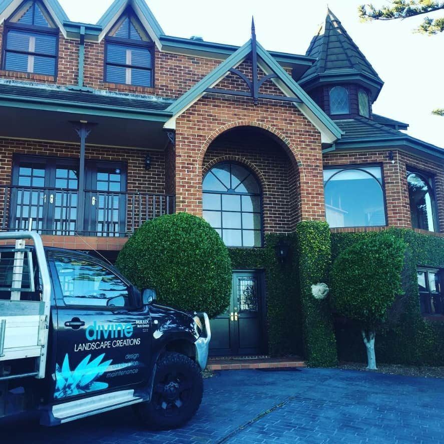Black Truck Parked in Front of a Brick House With Manicured Greenery — Divine Landscape Creations in Erina, NSW