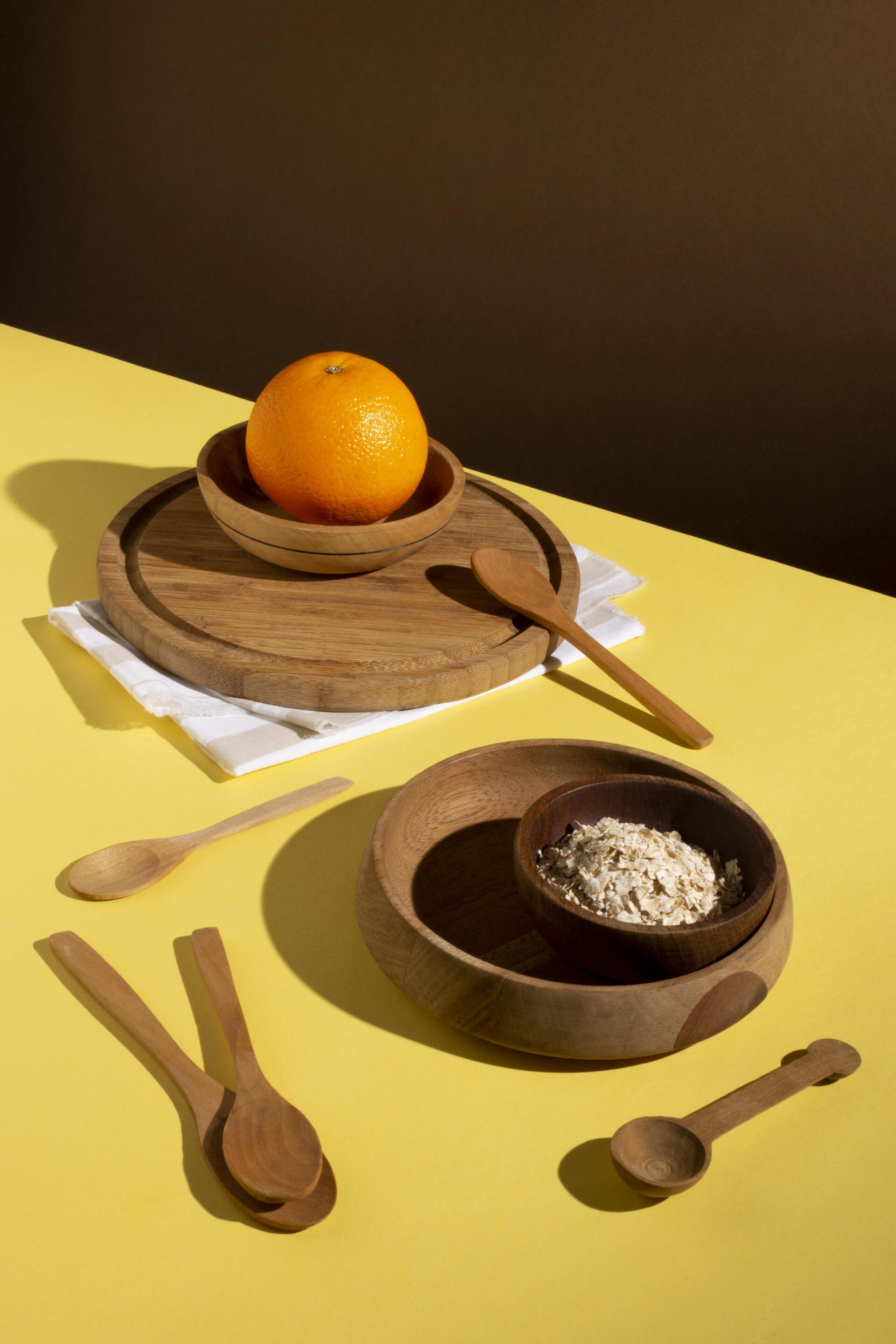 There is a bowl of oatmeal and an orange on the table.