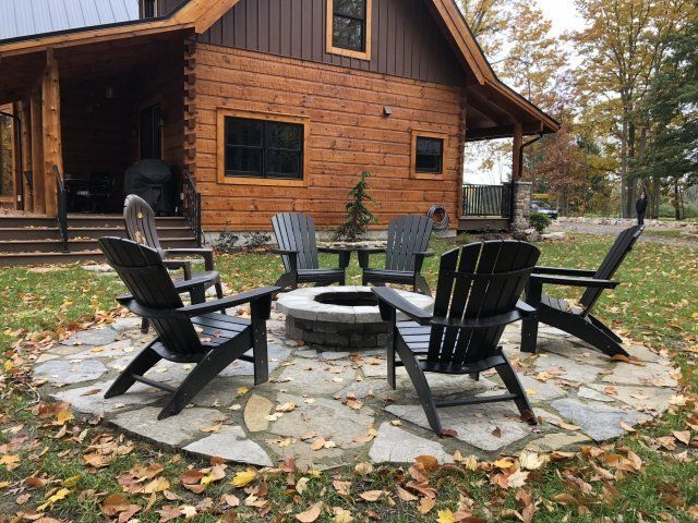 chairs around fire pit on stone pavers in yard