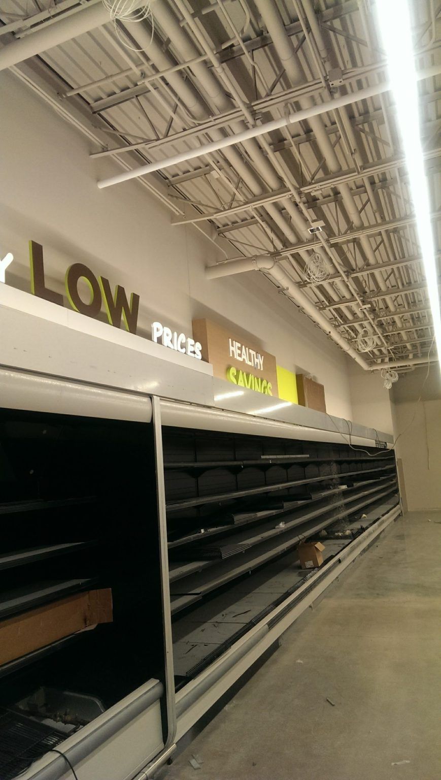 The inside of a grocery store with empty shelves.