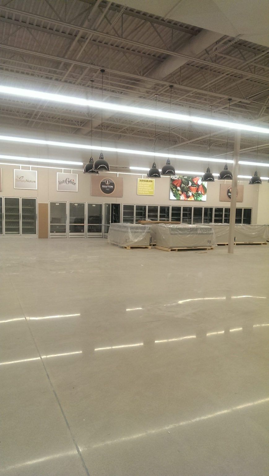 A large empty room in a building with a lot of lights on the ceiling.