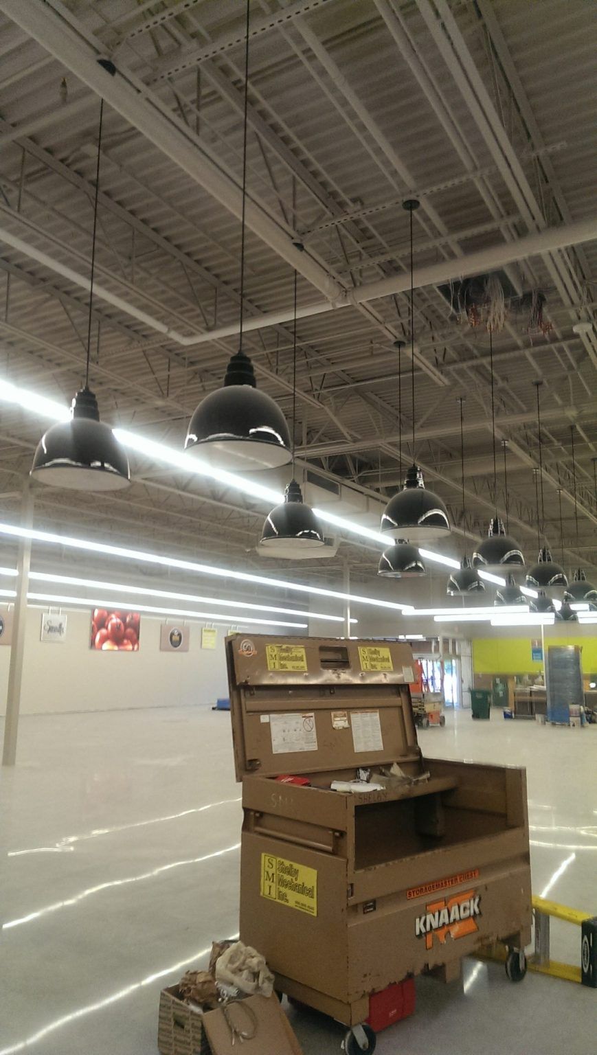 There are a lot of lights hanging from the ceiling of a store.