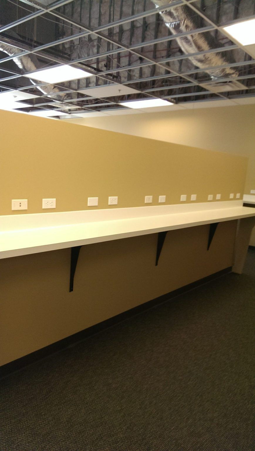 An empty office with a long desk and a ceiling light