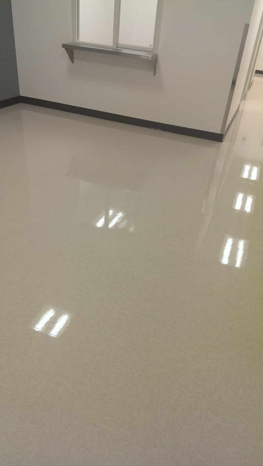 A room with a white floor and a window.