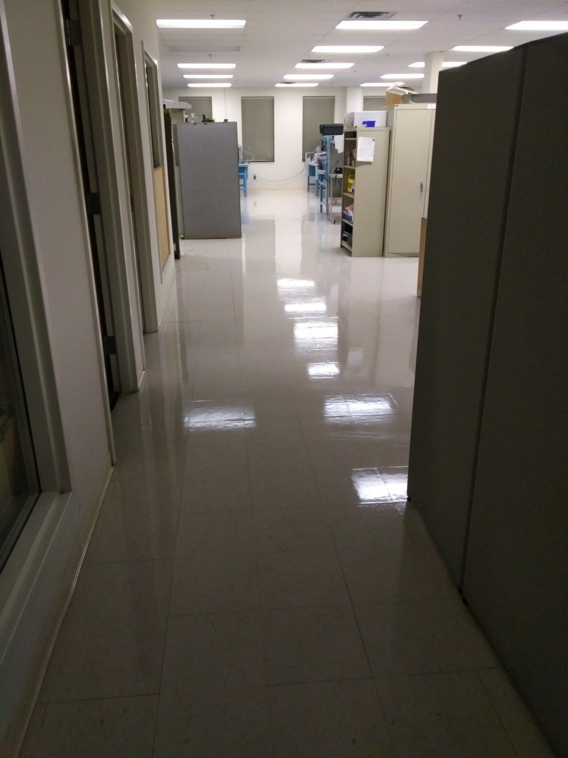 A hallway in a building with a lot of cubicles