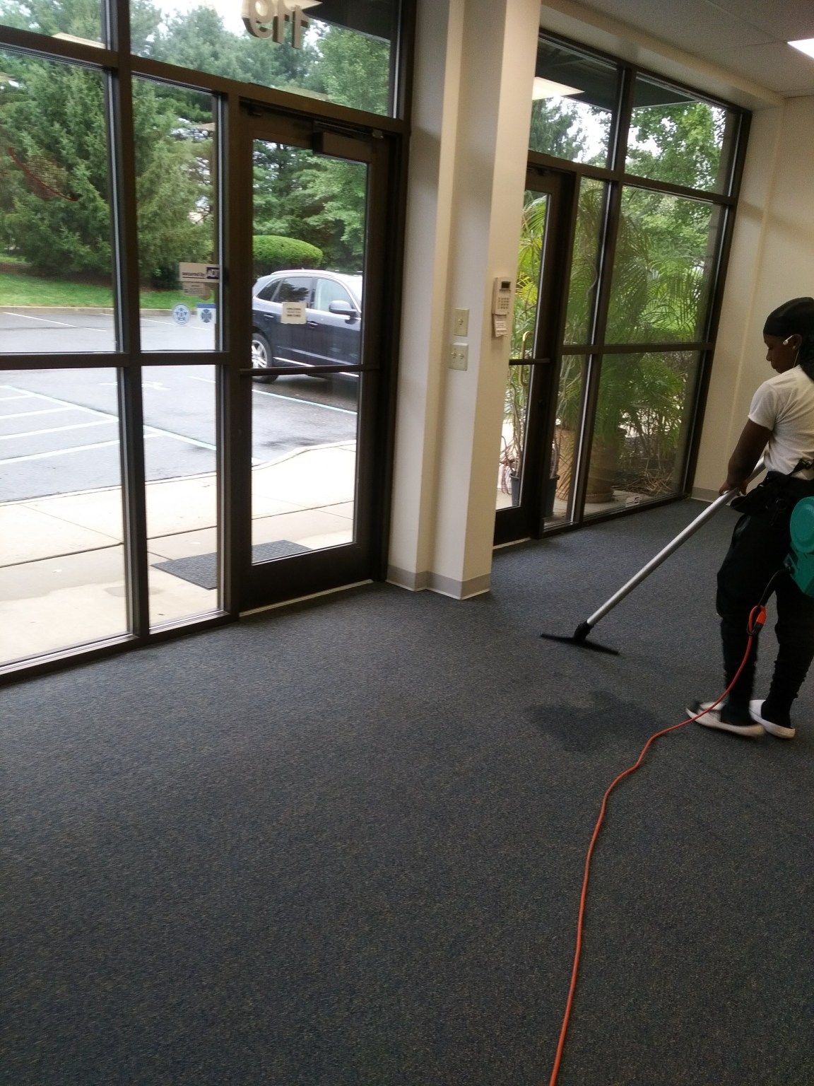A woman is cleaning a room with a vacuum cleaner
