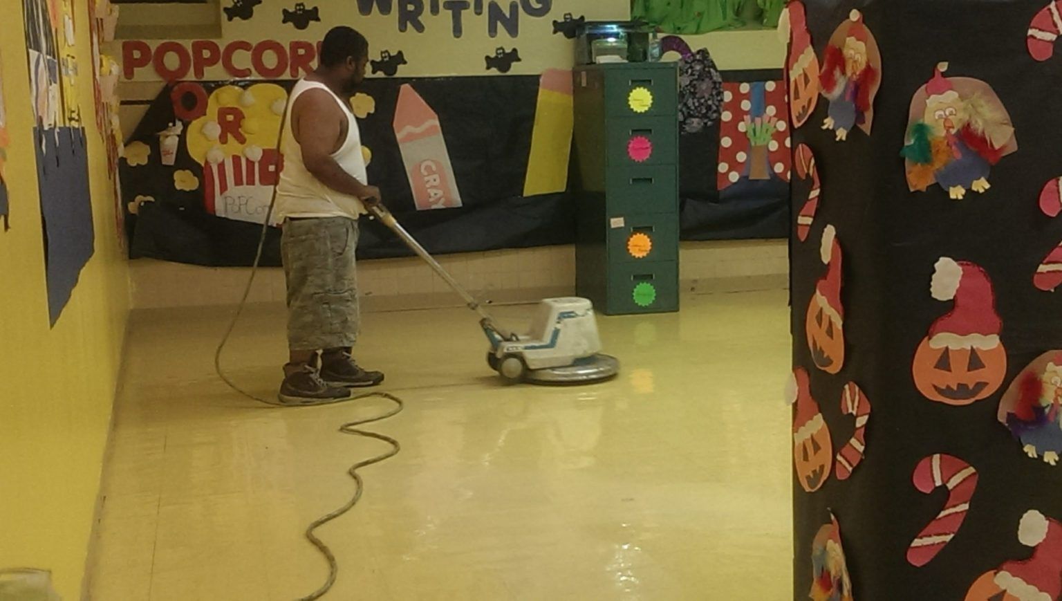 A man is using a vacuum cleaner to clean a hallway