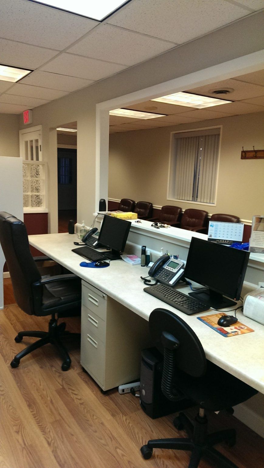 A row of desks with computers and chairs in an office