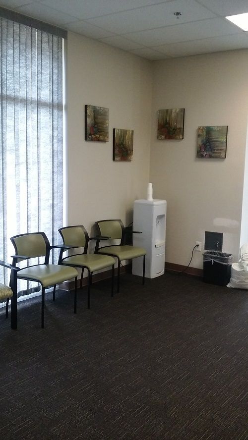 A waiting room with chairs and a water cooler.