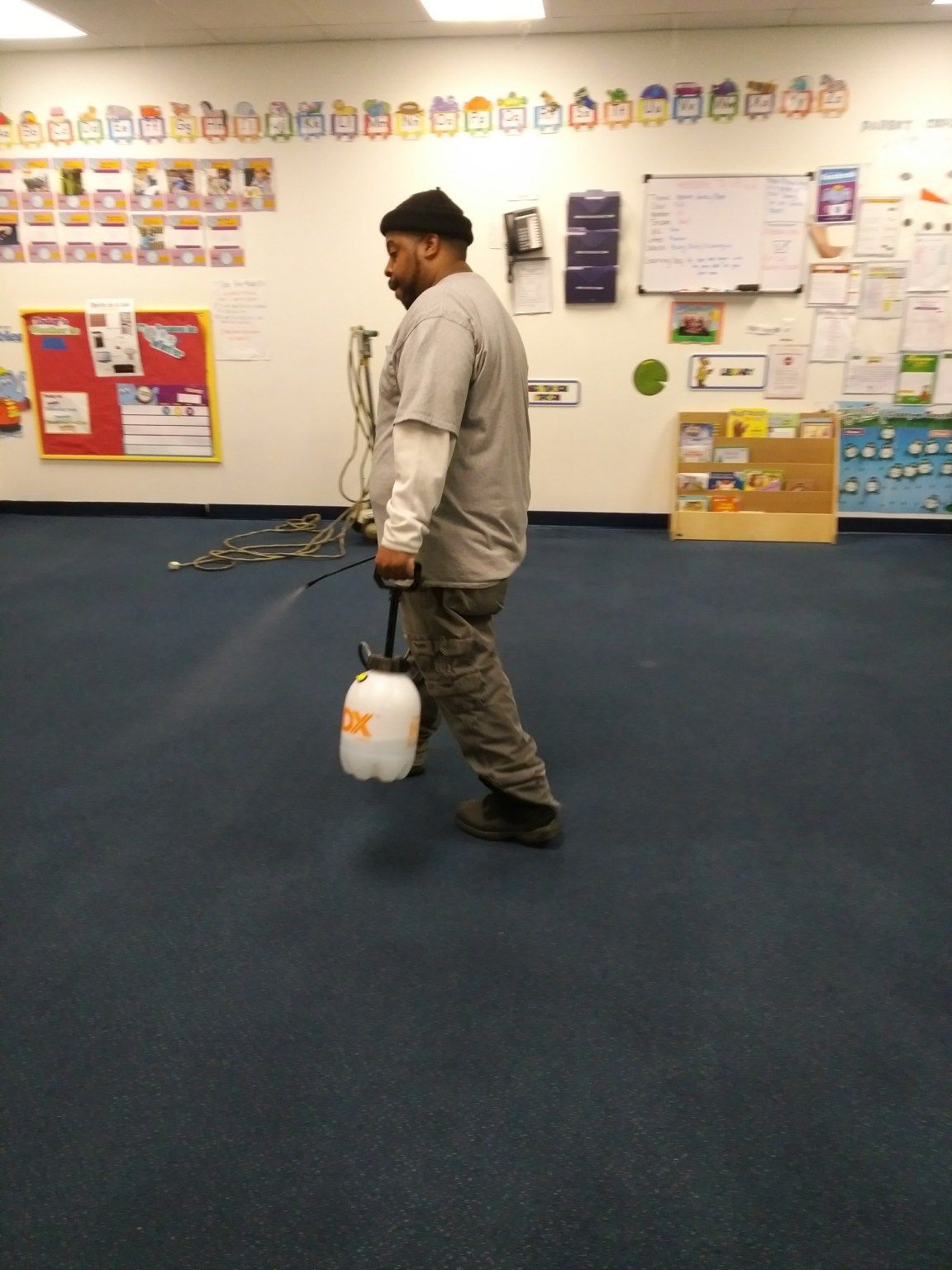A man is spraying a room with a spray bottle
