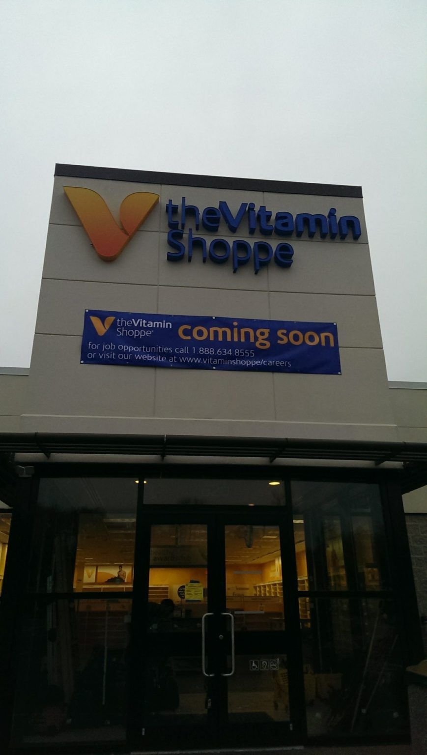A store front with a sign that says the vitamin shoppe coming soon
