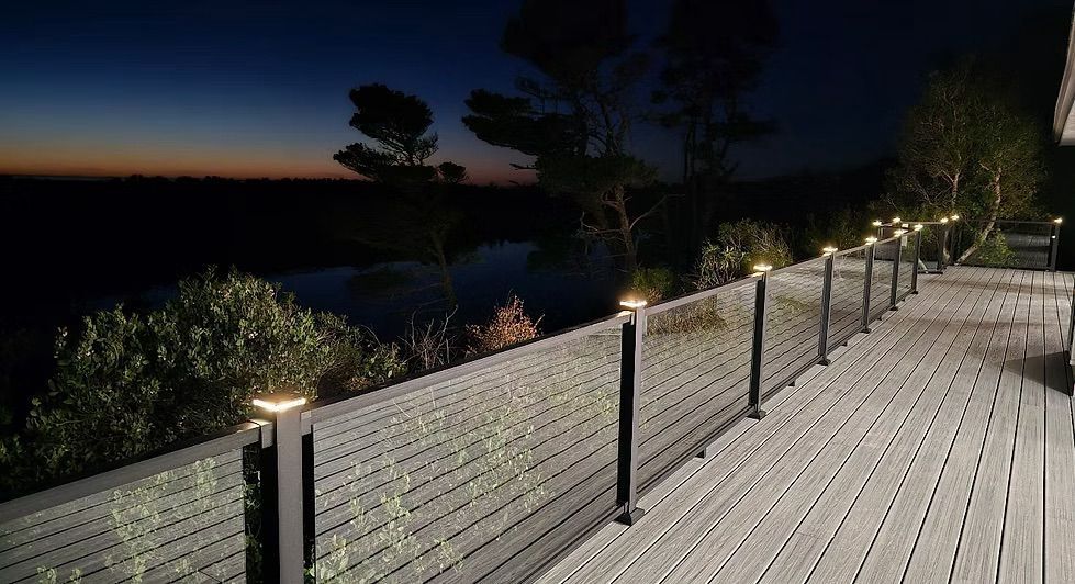 Deck overlooking water at dusk, with illuminated railing posts.