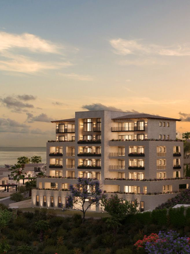 A row of cars are parked in front of a building.