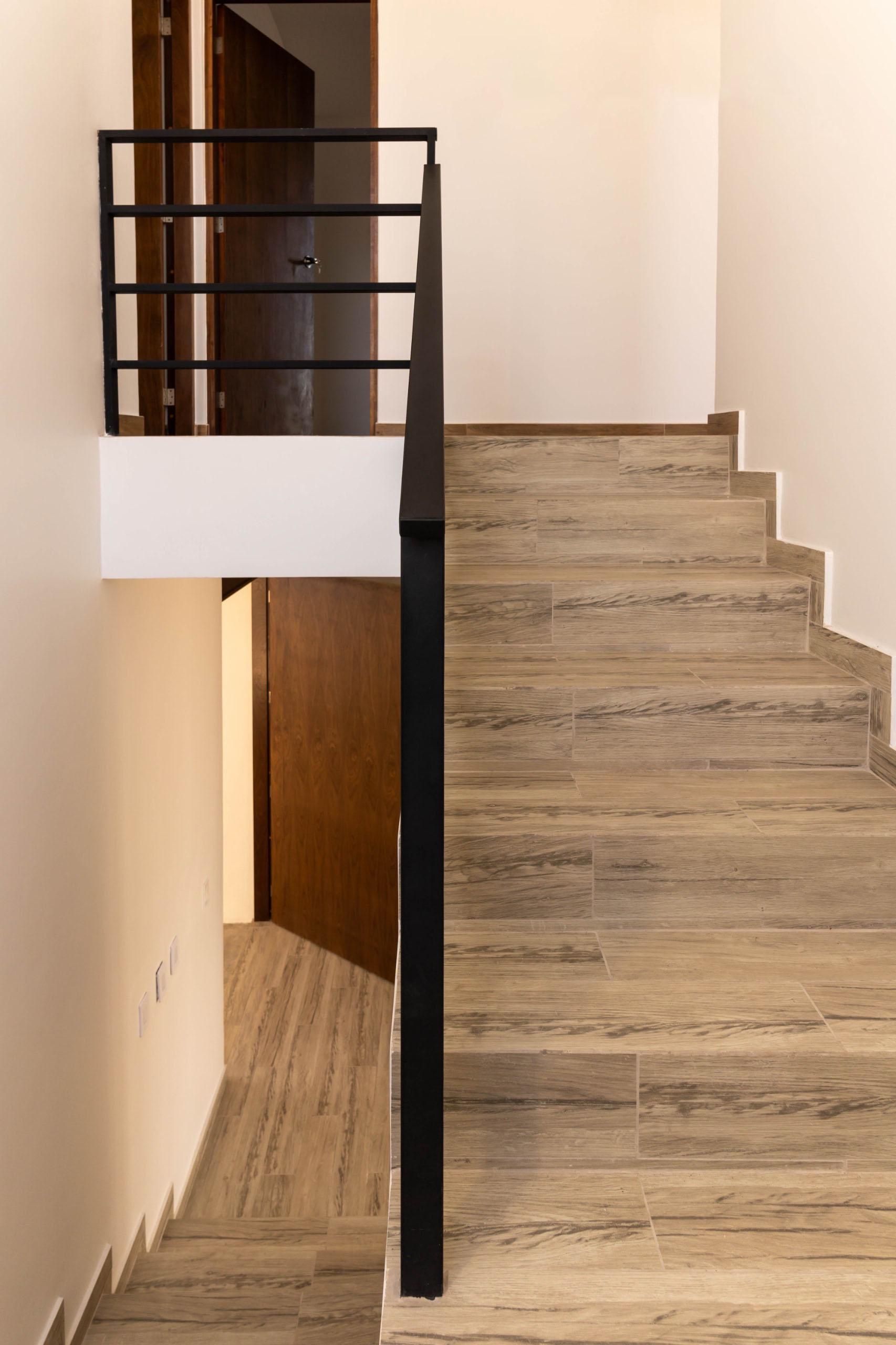 A staircase with wooden steps and a black railing in a house.