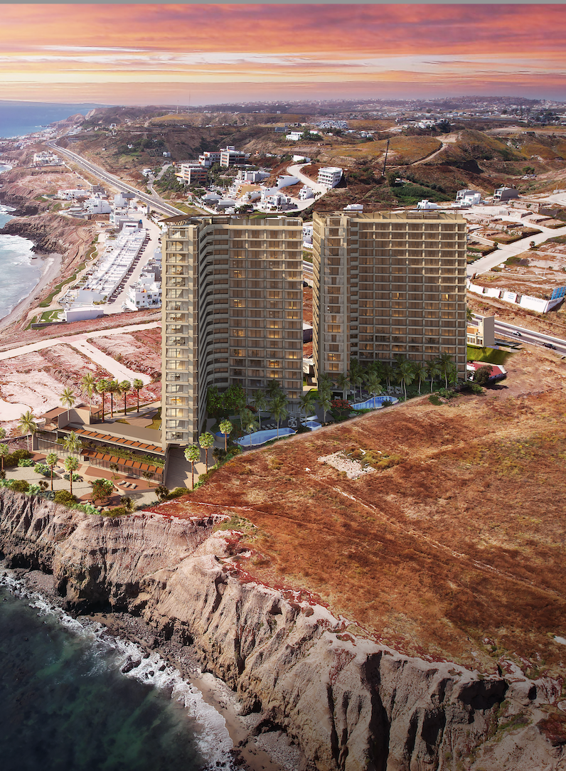 An aerial view of a building on a cliff overlooking the ocean.