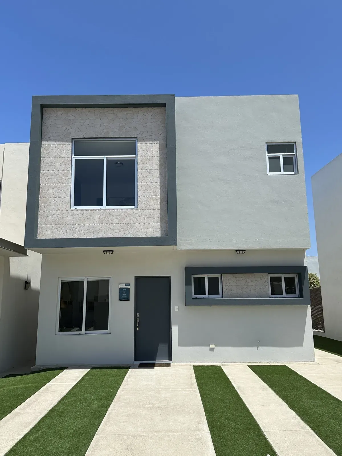 A large white house with a black garage door