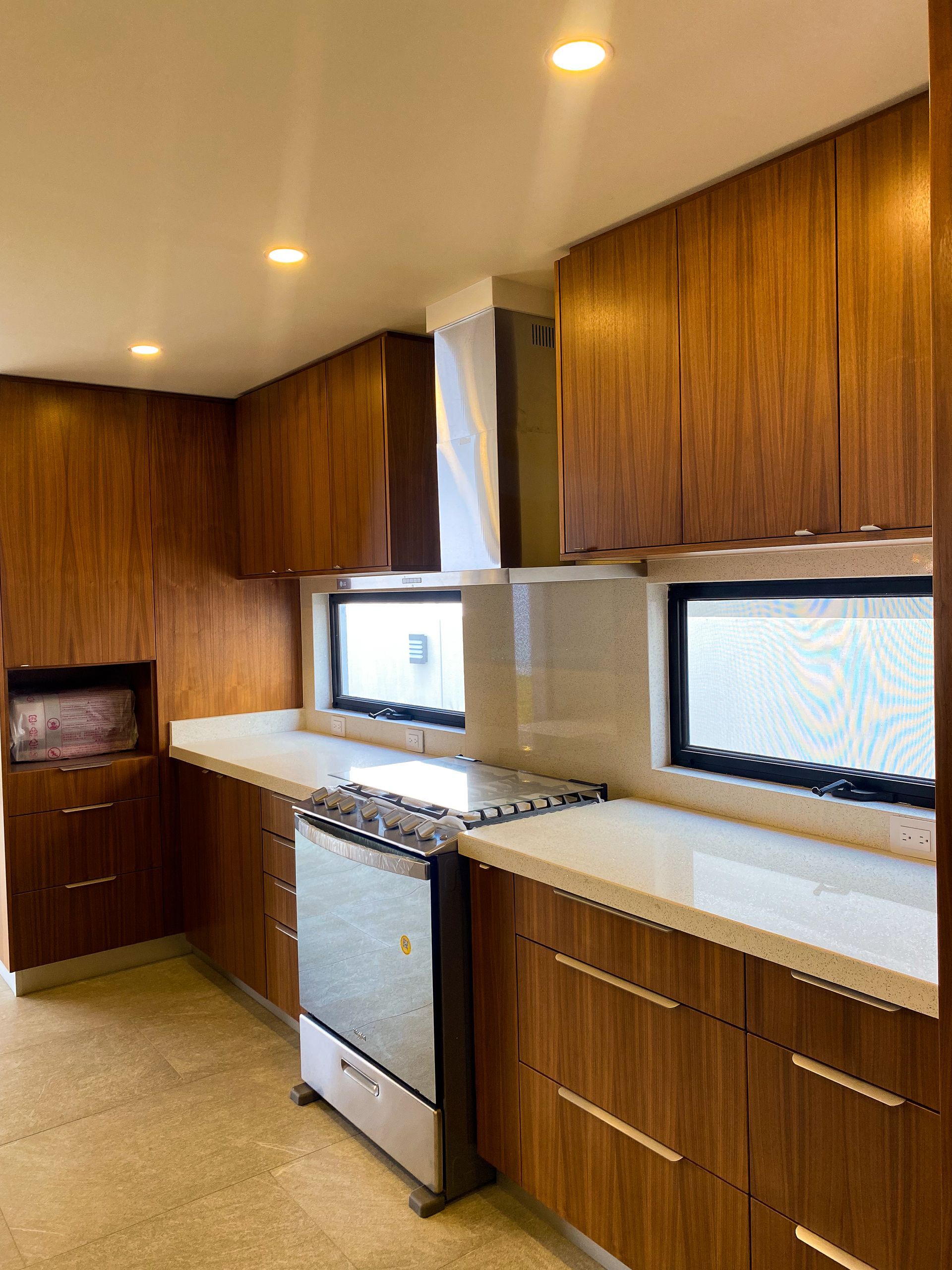 A kitchen with wooden cabinets , a stove and a microwave.