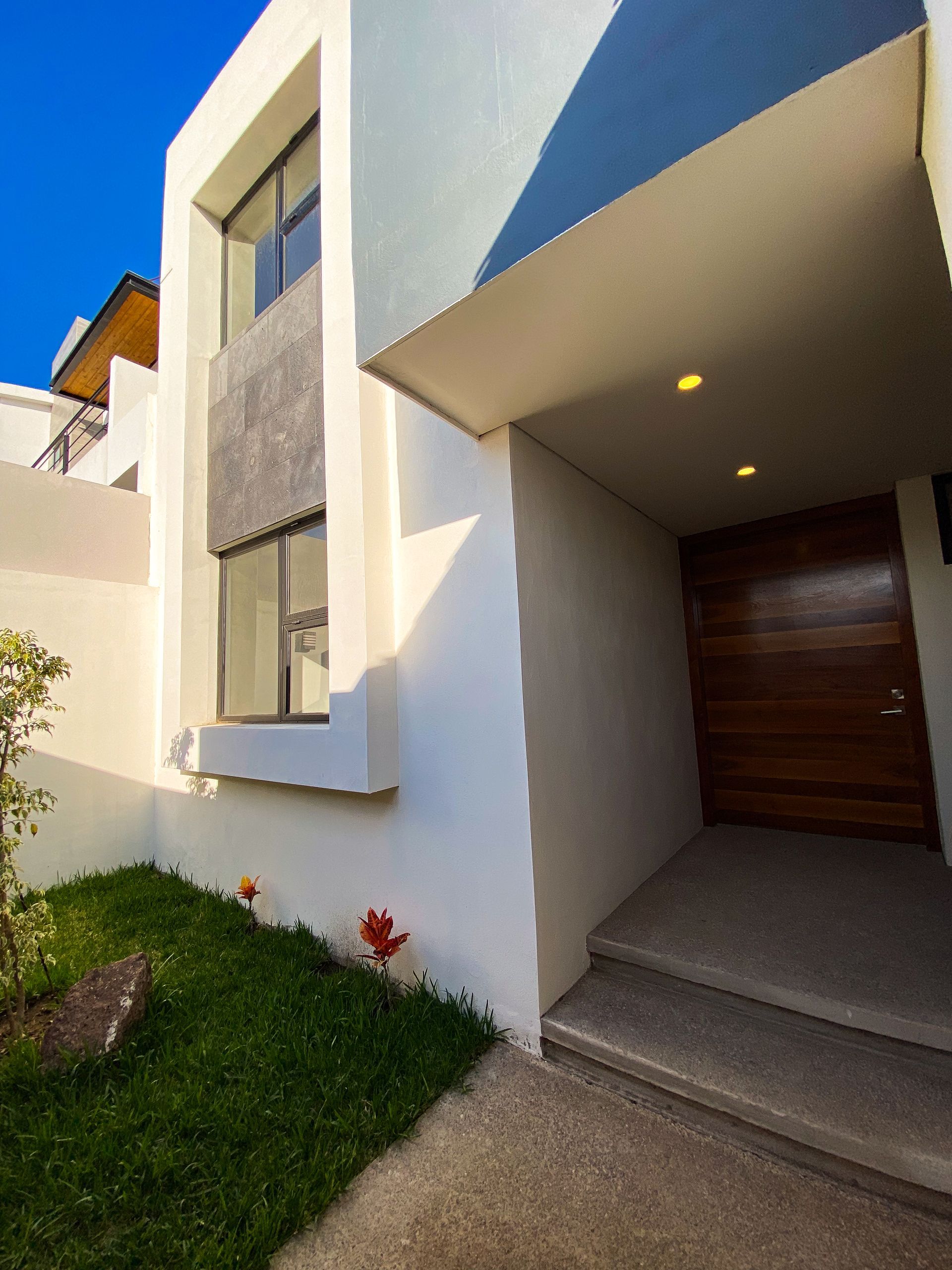 A white house with a wooden door and stairs
