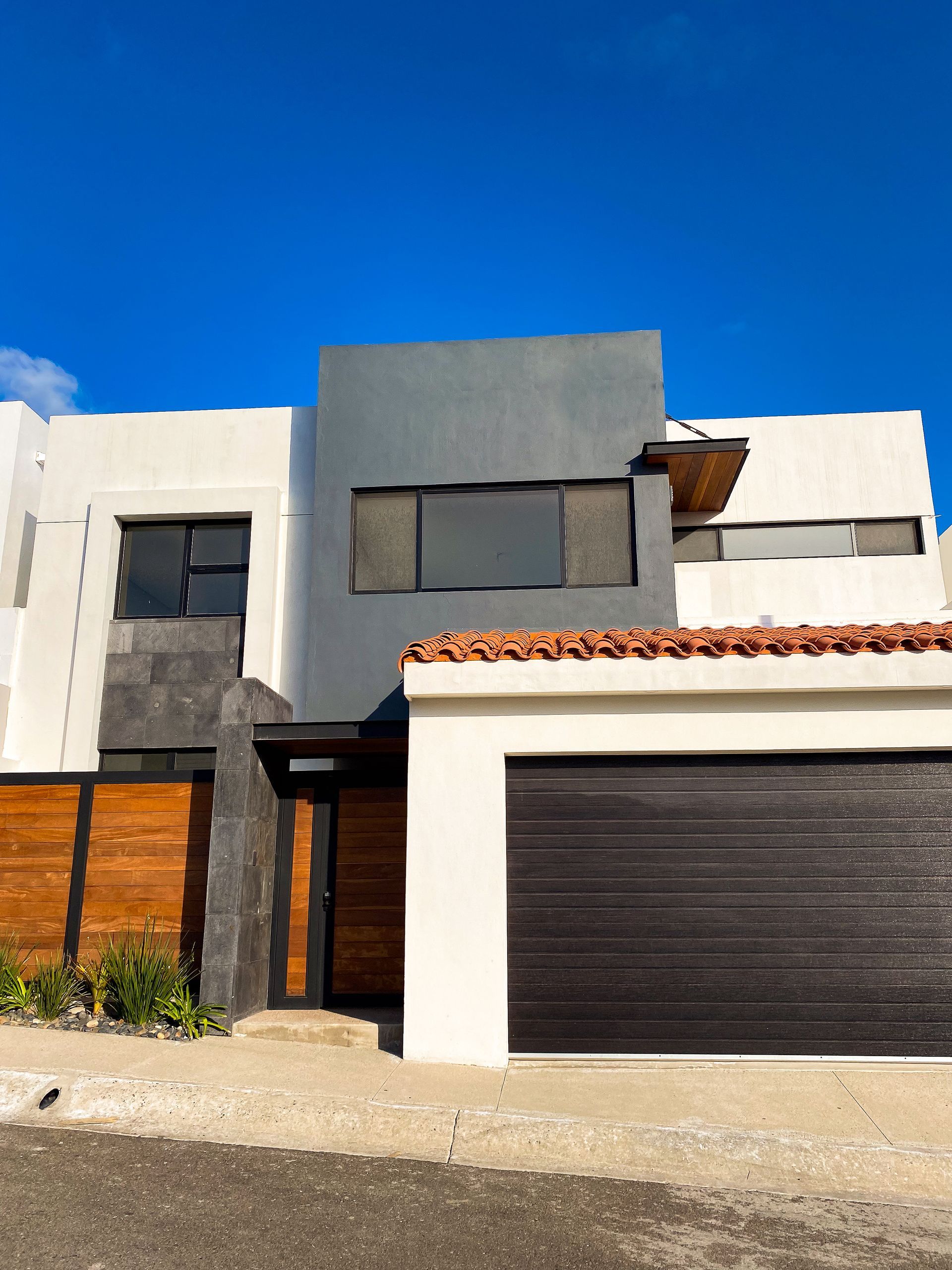 A large white house with a black garage door