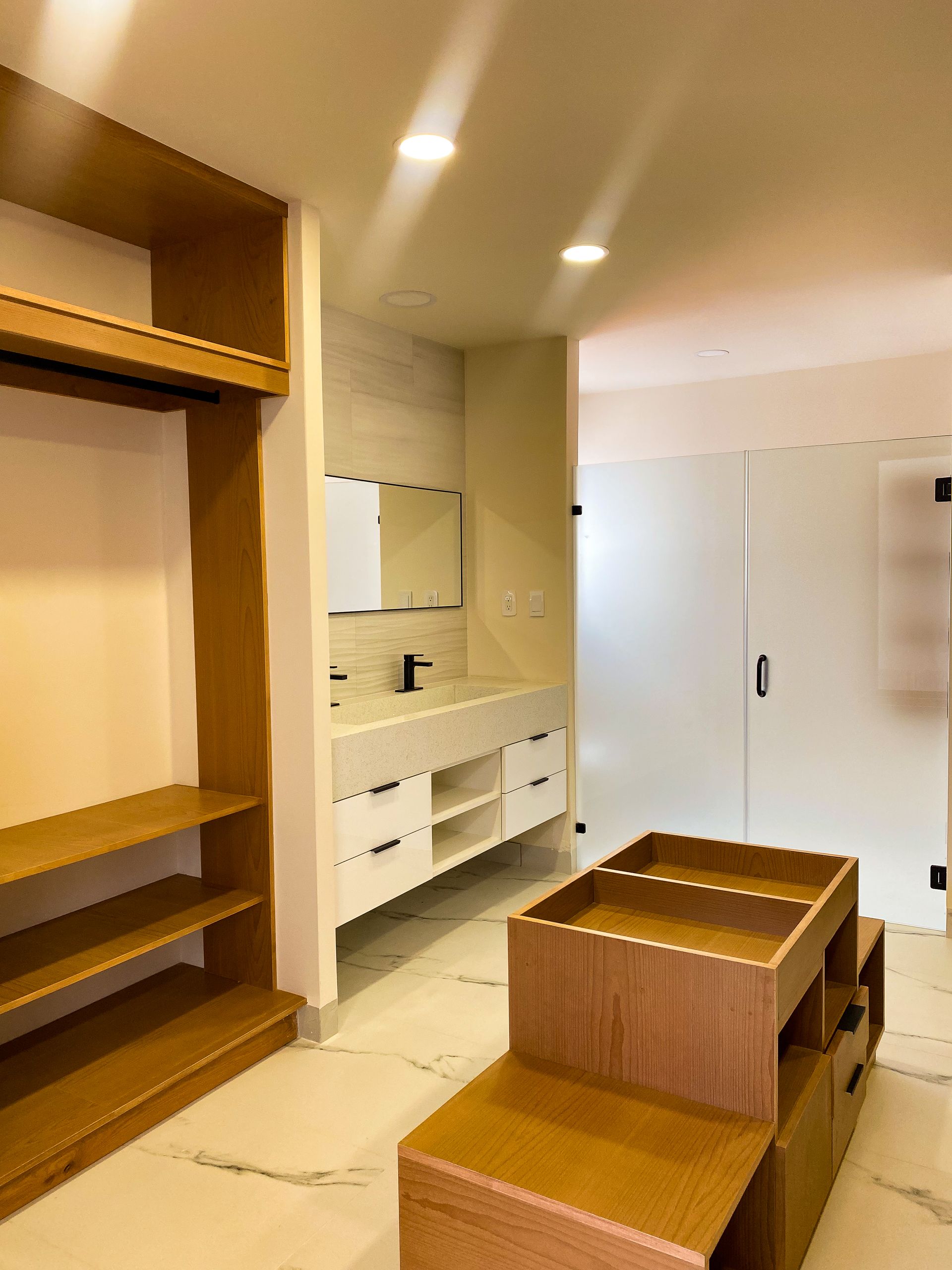 A walk in closet with a sink and a mirror