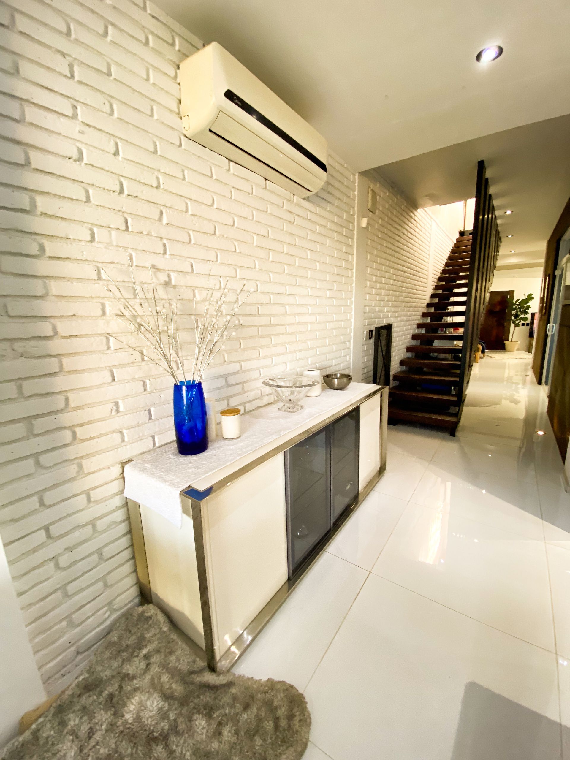 A white brick wall with a staircase in the background