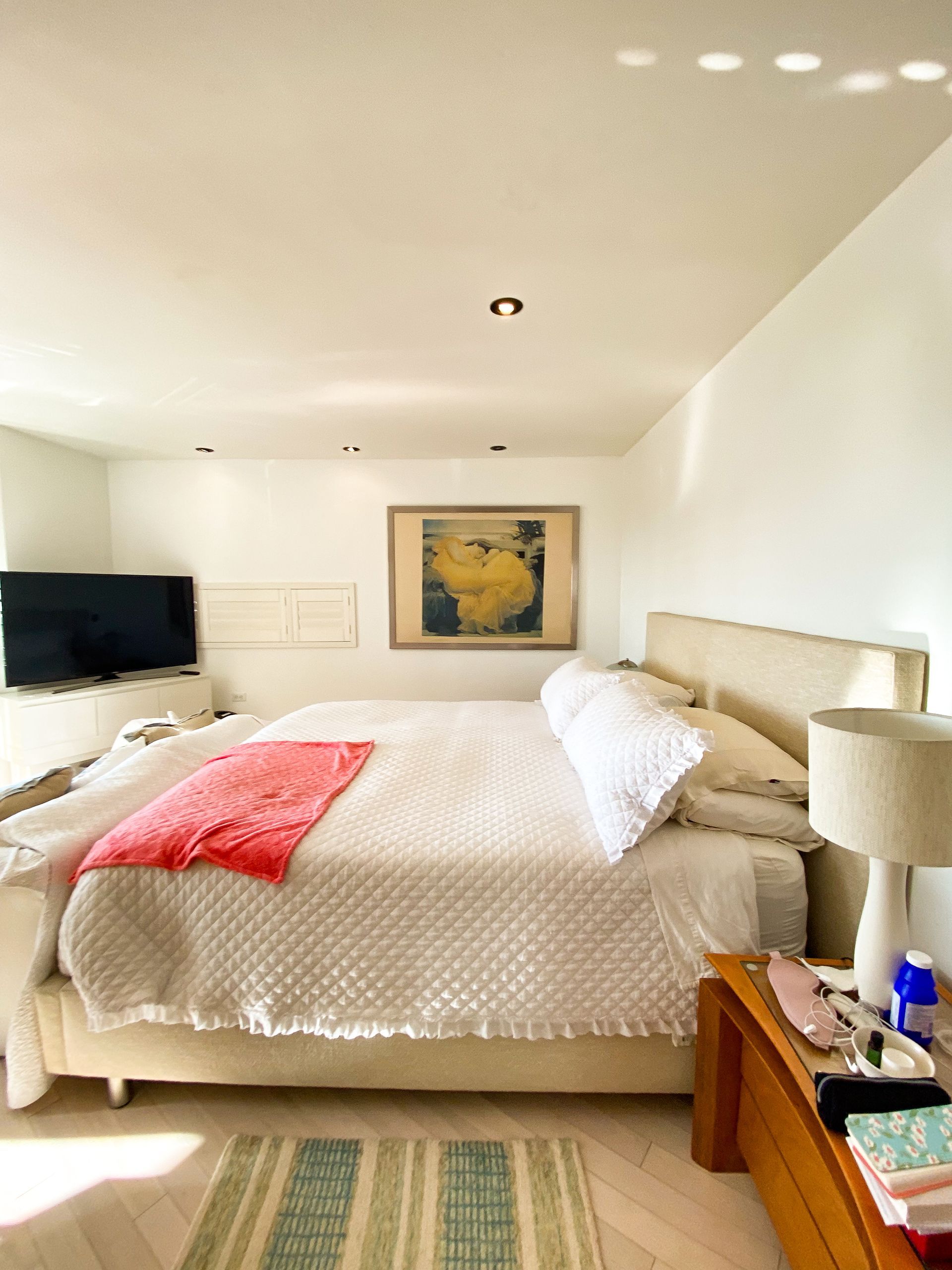 A bedroom with a large bed and a television