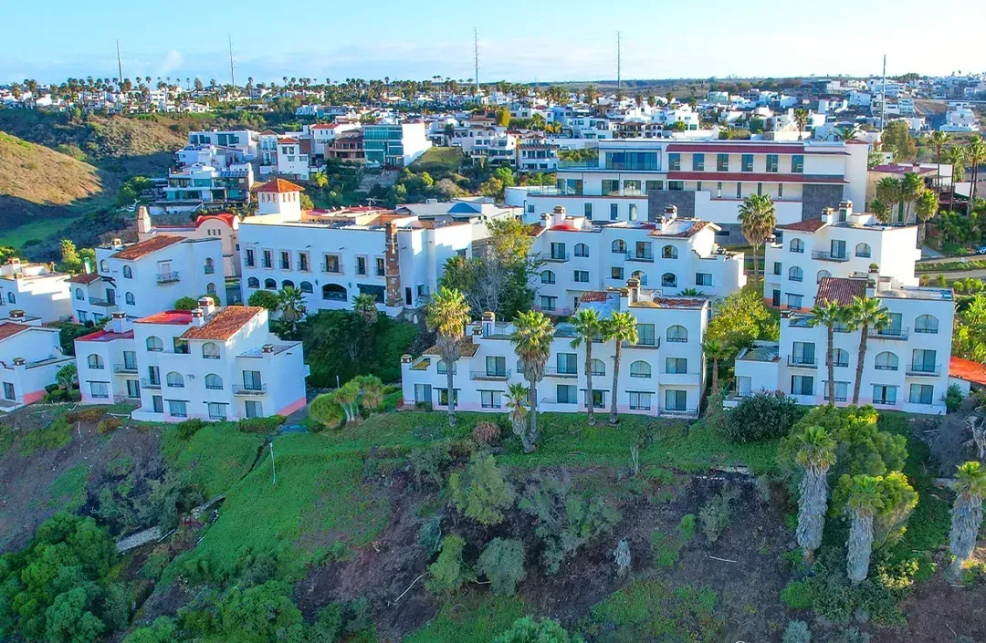 An aerial view of a building with a soccer field in front of it