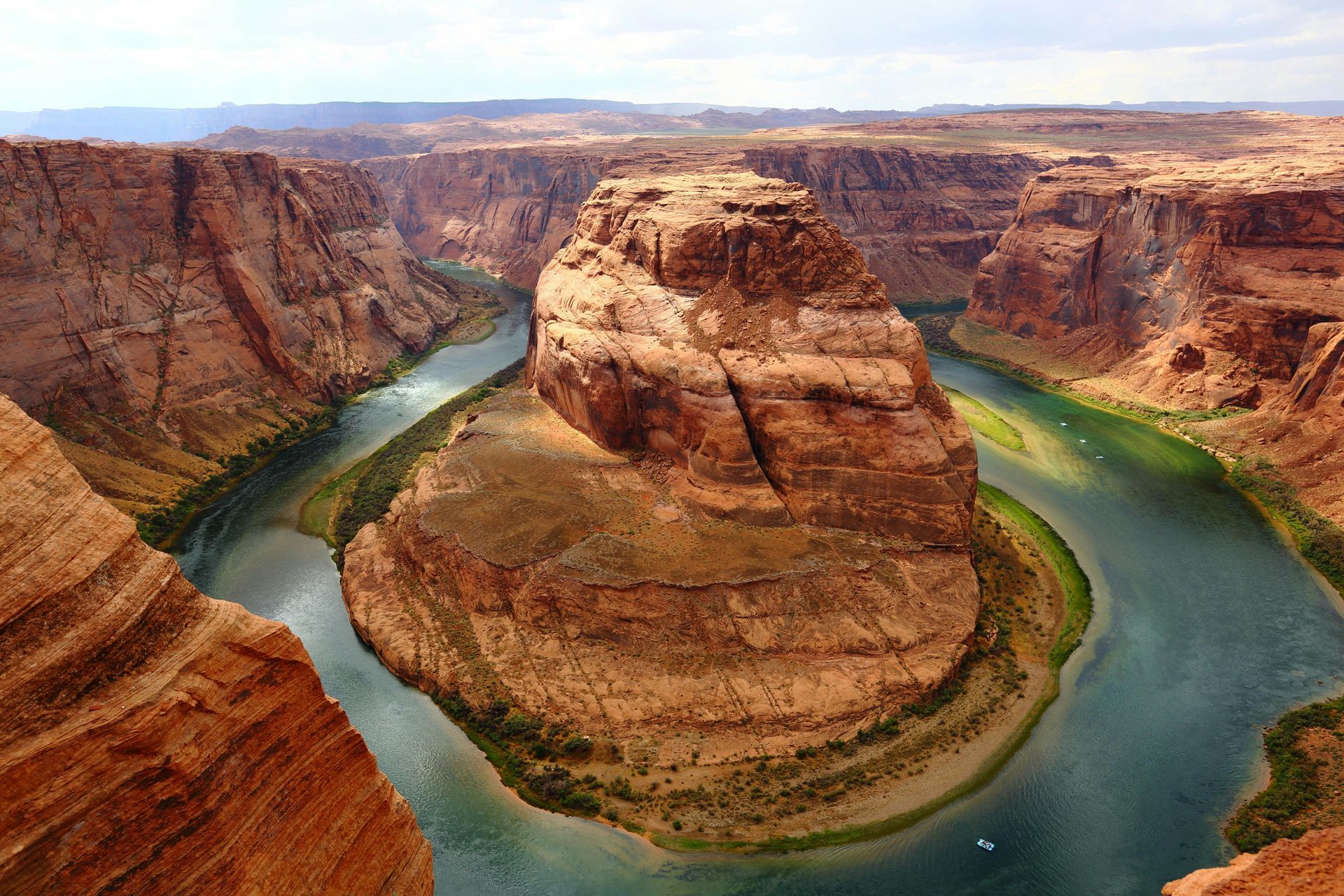 Horseshoe Bend in Arizona, a scenic canyon with the Colorado River in a horseshoe shape, brown cliffs, blue water.