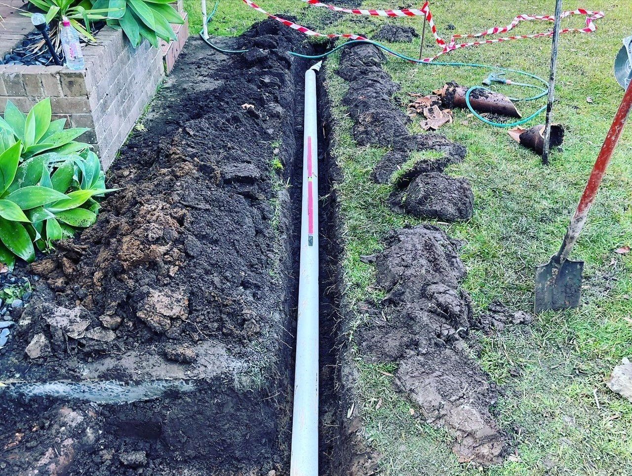 Laying Drainage Pipes Into The Ground — Distinct Plumbing Services In Barrack Heights NSW