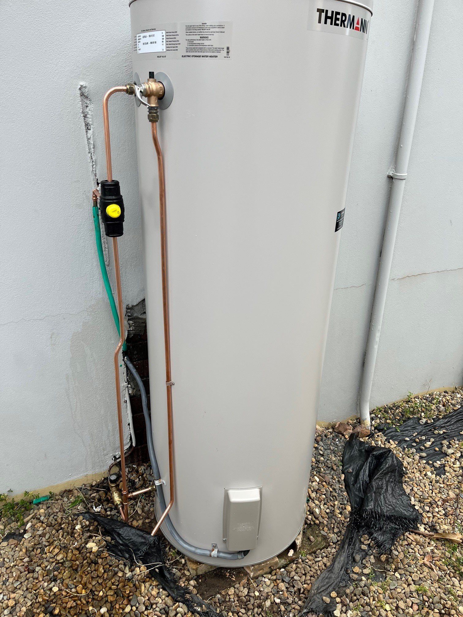 Man's Hands Unscrewing A Screw Nut On A Water Heater — Distinct Plumbing Services In Barrack Heights NSW