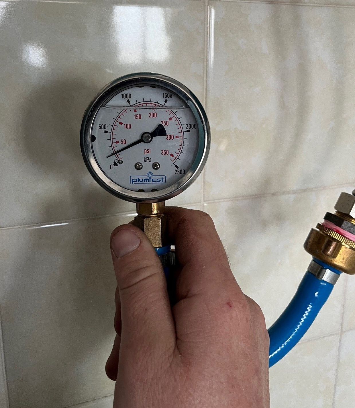 Male Plumber Fixing White Sink Pipe With Adjustable Wrench — Distinct Plumbing Services In Barrack Heights NSW