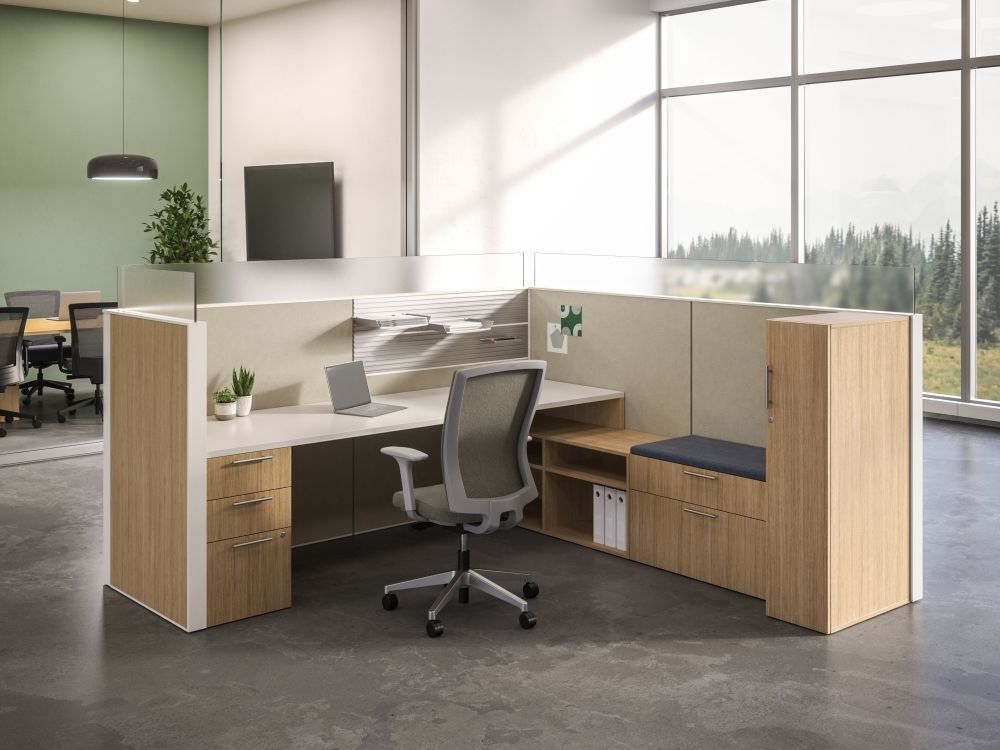 A cubicle with a desk and chair in an office.