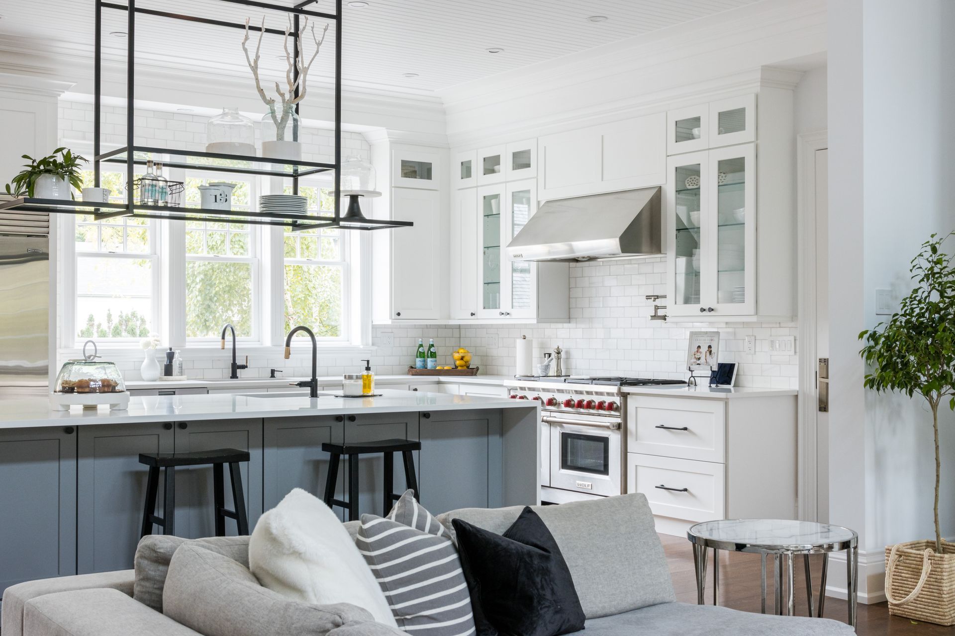 A living room with a couch and a kitchen in the background.