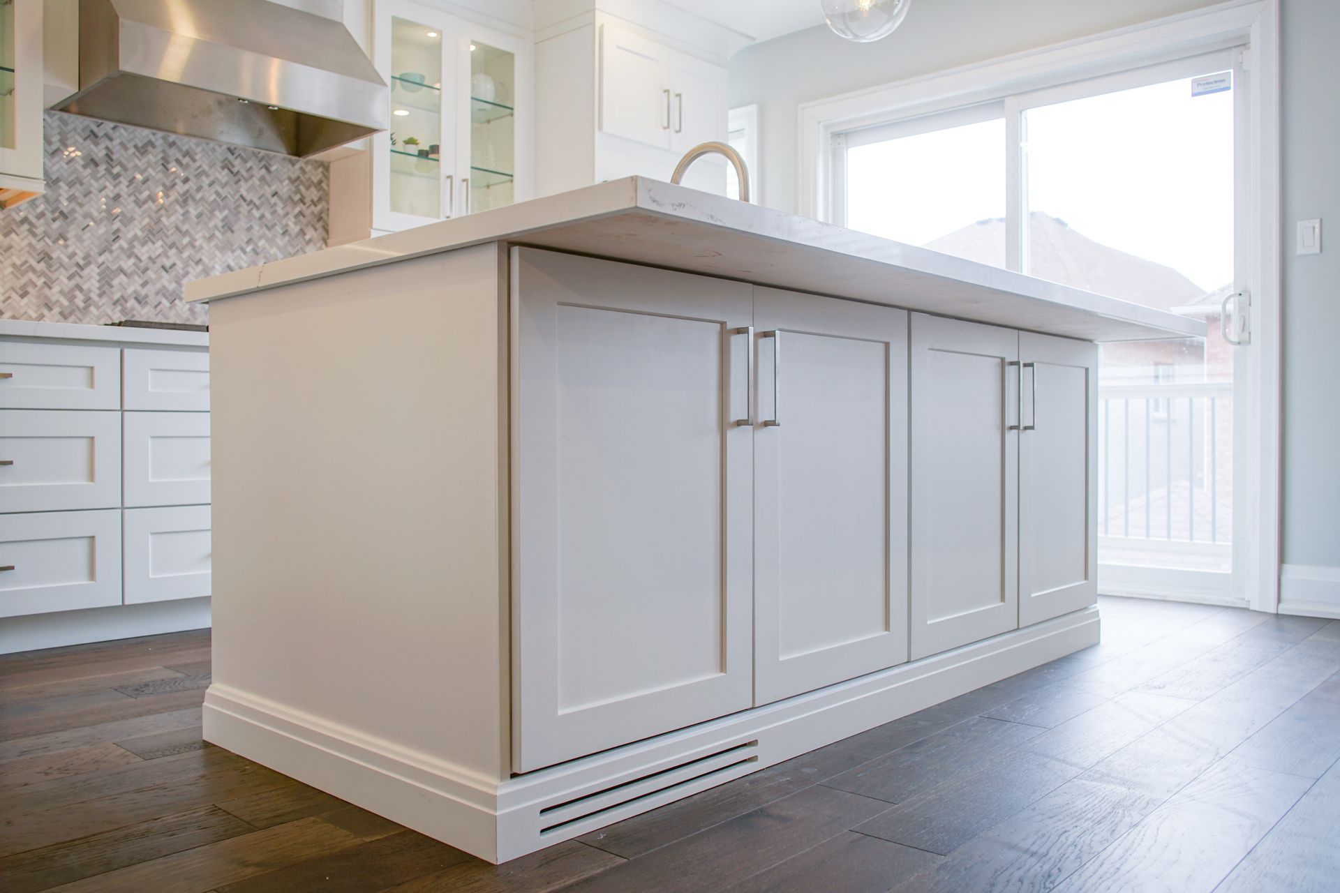 A kitchen with white cabinets and a large island in the middle.