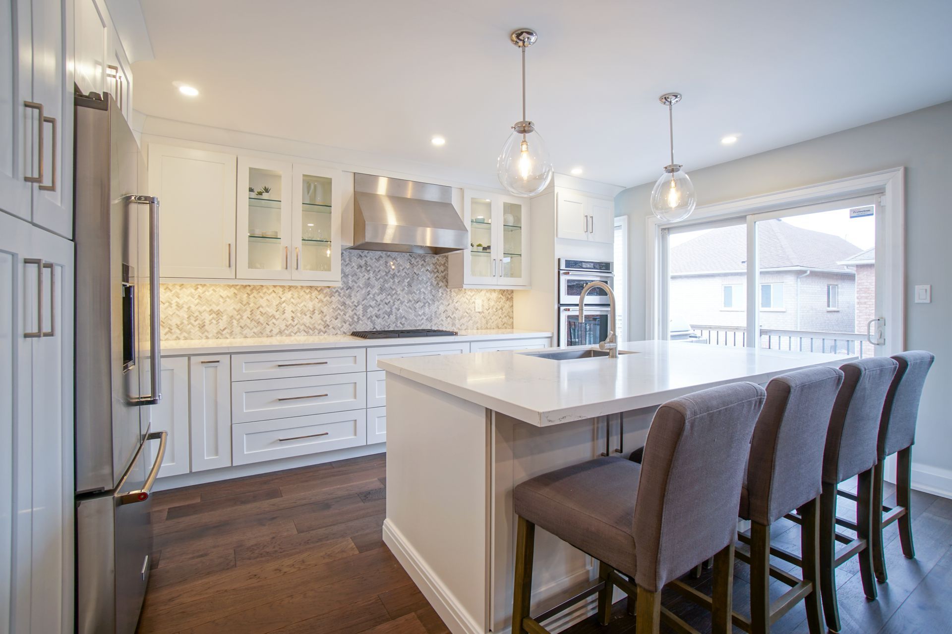 A kitchen with white cabinets and stainless steel appliances and a large island.