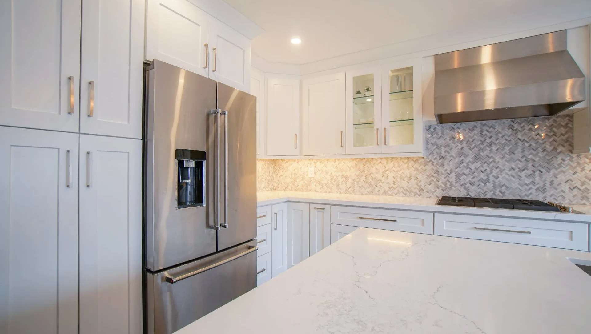 a kitchen with white cabinets and stainless steel appliances .